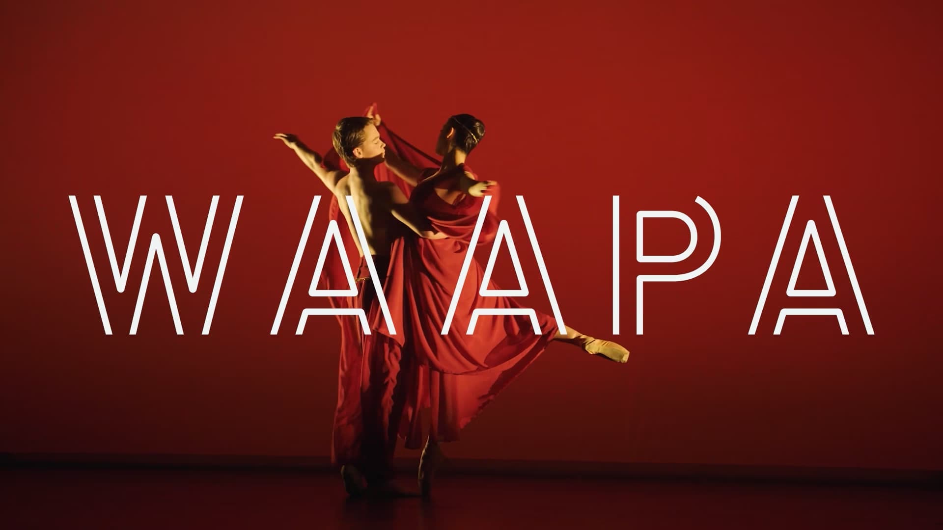 Dancers wearing red on a stage with a red background with the word WAAPA overlayed on top