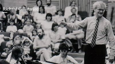 Black and white photo of Richard Gill in front of an audience